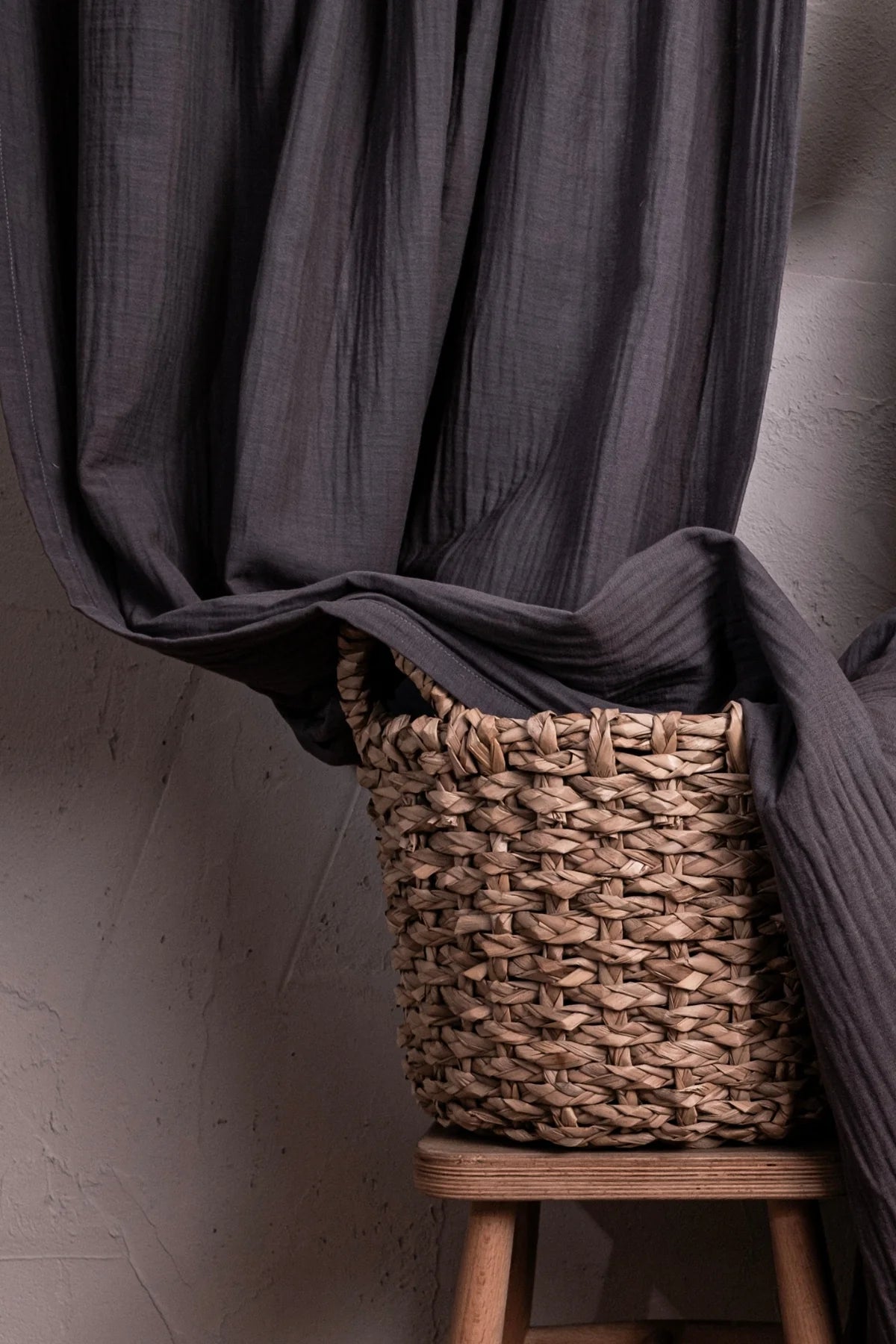 Gray muslin draped into basket on stool. Handwoven 2-layer muslin cotton curtain, Denizli, OEKO-TEX. Vivamaison.
