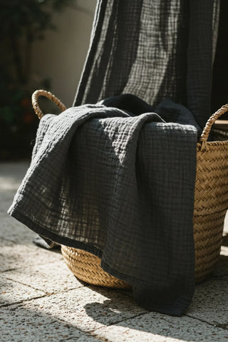 Dark gray gauze draped over outdoor basket. Handwoven 2-layer muslin cotton curtain, Denizli, OEKO-TEX. Vivamaison.