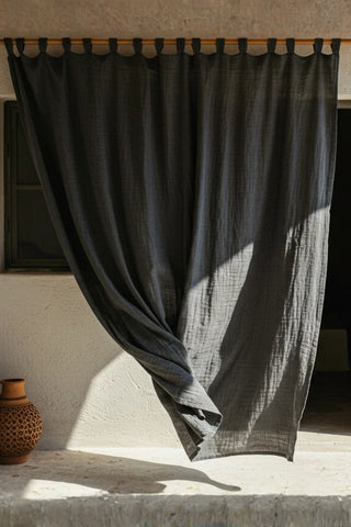 Gray tab top panel outdoors, sunlit sheer. Handwoven 2-layer muslin cotton curtain, Denizli, OEKO-TEX. Vivamaison.
