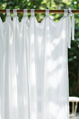 White tab top closeup, knotted end tie, wooden rod. Handwoven 2-layer muslin cotton curtain, Denizli, OEKO-TEX. Vivamaison.