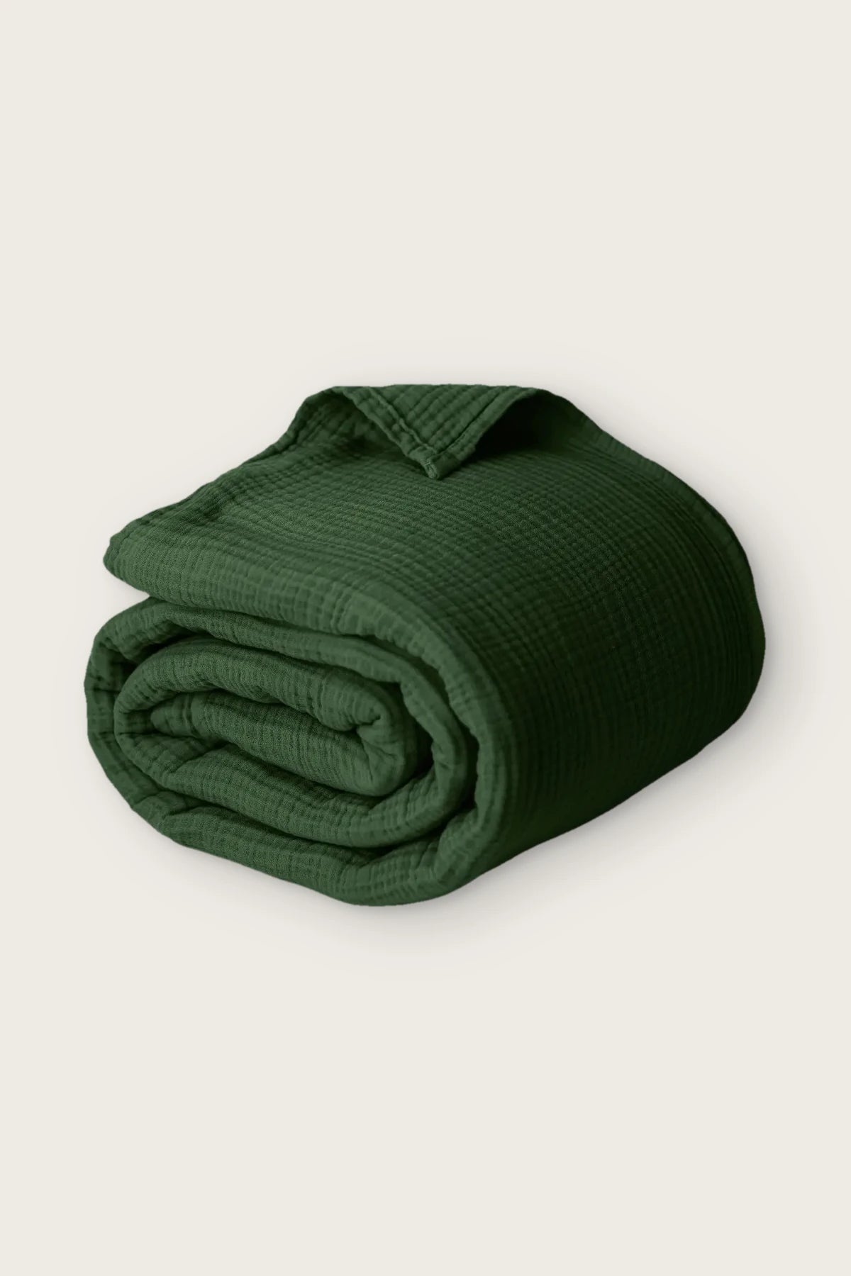 Handwoven 4-layer muslin cotton bedspread in dark green, rolled front view
