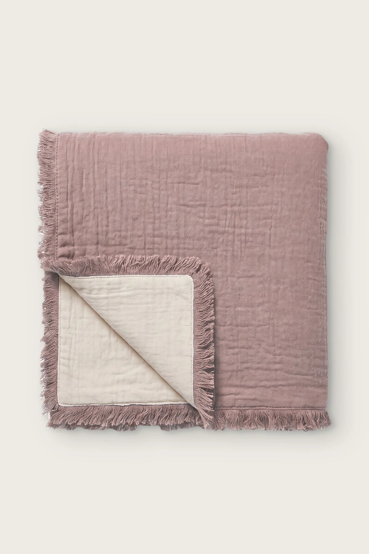 Handwoven 4-layer soft muslin fringed bedspread in plum, folded front view showing reversible cream side