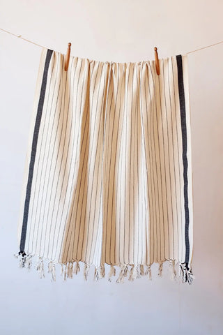 Black luxury striped peshtemal towel hanging full view. Handwoven Turkish cotton Denizli, OEKO-TEX. Vivamaison.