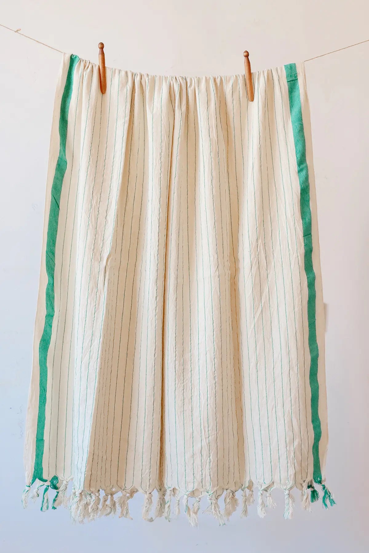 Green luxury striped peshtemal towel hanging full view. Handwoven Turkish cotton Denizli, OEKO-TEX. Vivamaison.