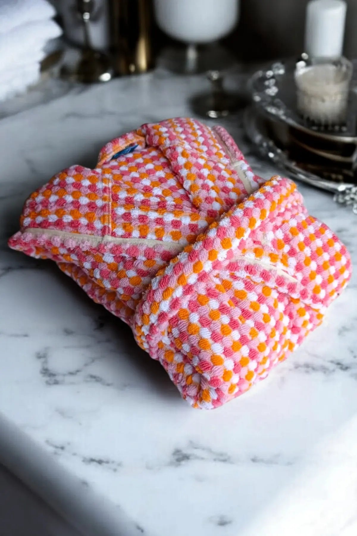 Pink orange mosaic bathrobe folded flat lay. Handwoven Turkish cotton Denizli, OEKO-TEX. Vivamaison.