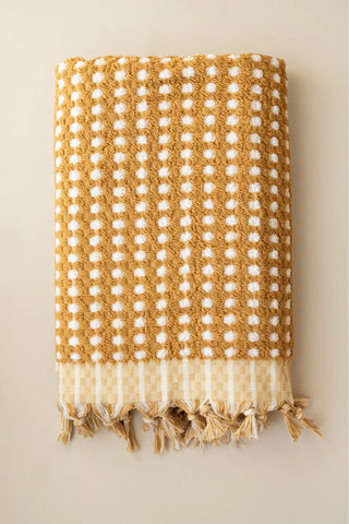 Mustard handwoven Turkish cotton pom pom woven towel set folded. Tasseled fringe Denizli, OEKO-TEX. Vivamaison.
