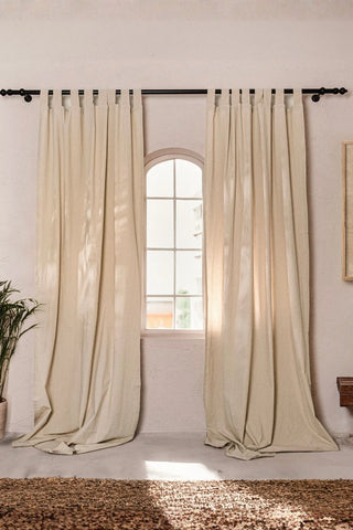 Beige stonewashed cotton curtain panels framing an arched window. Handwoven in Denizli, OEKO-TEX. Vivamaison.
