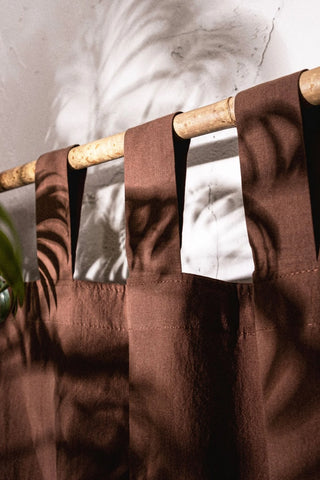 Brown stonewashed cotton curtain tab top loops on a bamboo rod, close-up. Handwoven in Denizli, OEKO-TEX. Vivamaison.