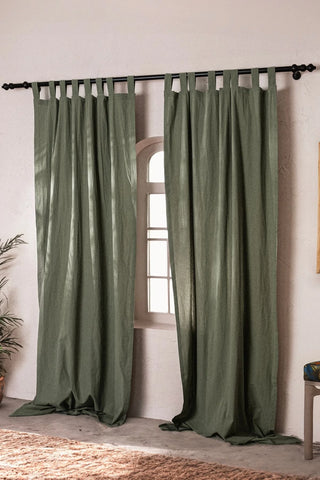 Dark green stonewashed cotton curtain panels framing an arched window. Handwoven in Denizli, OEKO-TEX. Vivamaison.