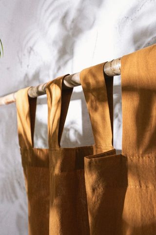 Terracotta stonewashed cotton curtain tab top loops on a bamboo rod. Handwoven in Denizli, OEKO-TEX. Vivamaison.