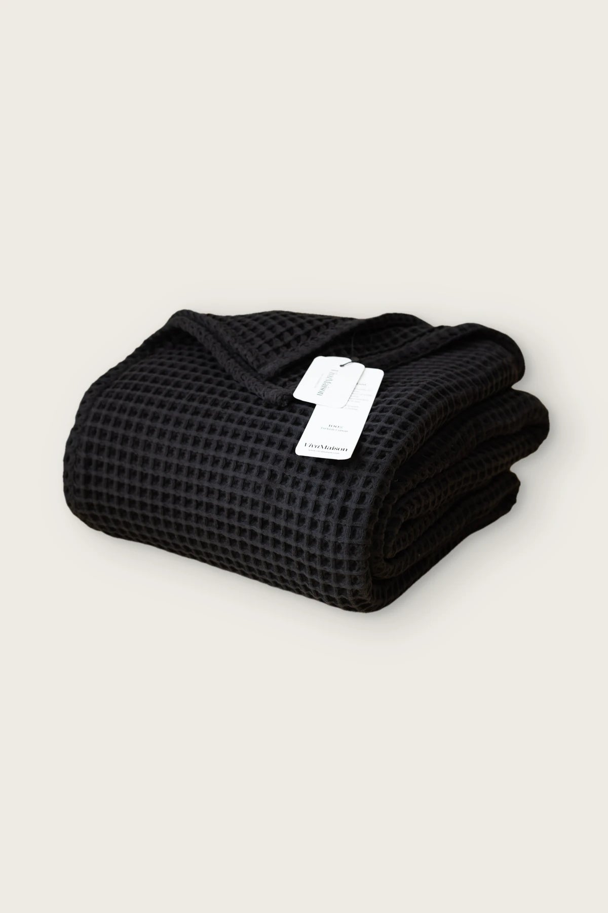 Handwoven Turkish cotton waffle weave bedspread in black, folded front view