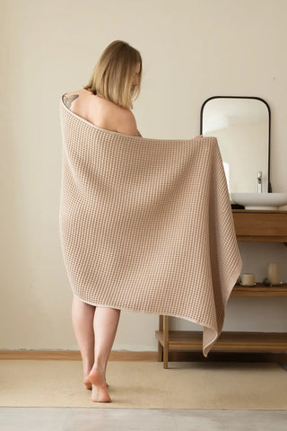 Brown handwoven Turkish cotton waffle weave towel lifestyle shoulder drop. Denizli, OEKO-TEX. Vivamaison.