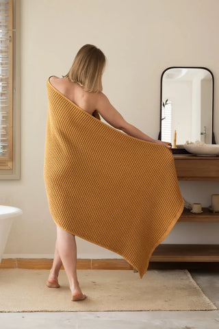 Caramel handwoven Turkish cotton waffle weave towel lifestyle shoulder drop. Denizli, OEKO-TEX. Vivamaison.