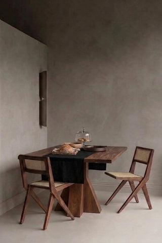 Black plain linen cotton blend table runner styled in a modern dining room with cane chairs. 16 x 51 in, handmade in Denizli, OEKO-TEX. VivaMaison.