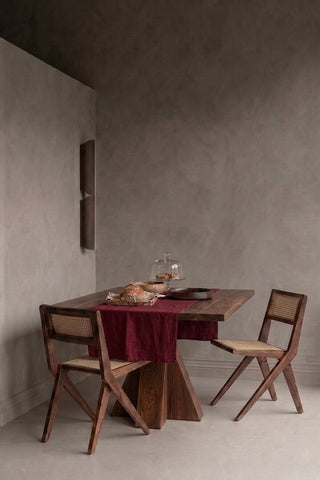 Burgundy plain linen cotton blend table runner styled in a modern dining room with cane chairs. 16 x 51 in, handmade in Denizli, OEKO-TEX. VivaMaison.