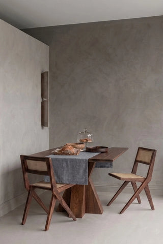 Gray plain linen cotton blend table runner styled in a modern dining room with cane chairs. 16 x 51 in, handmade in Denizli, OEKO-TEX. VivaMaison.