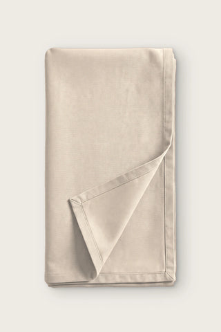 Plain linen cotton blend table runner in natural, folded in half with corner turned back