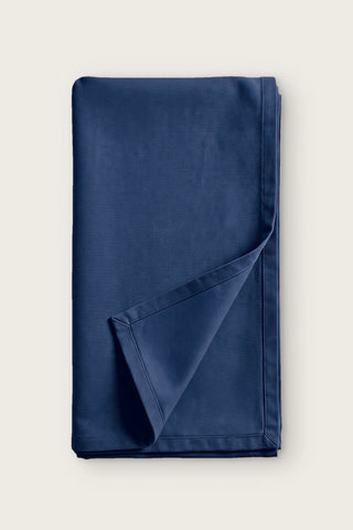 Plain linen cotton blend table runner in navy, folded in half with corner turned back
