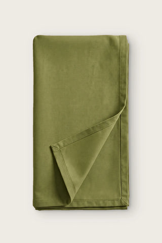 Plain linen cotton blend table runner in olive green, folded in half with corner turned back