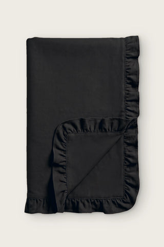 Ruffled linen cotton blend table runner in black, folded in half with corner turned back