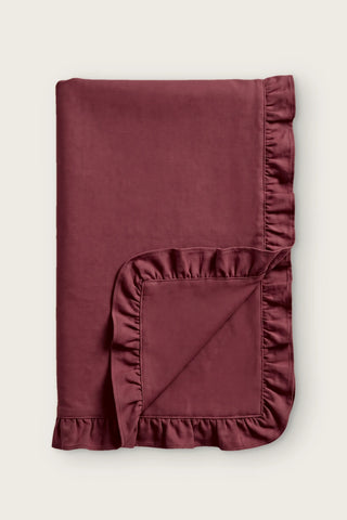 Ruffled linen cotton blend table runner in burgundy, folded in half with corner turned back
