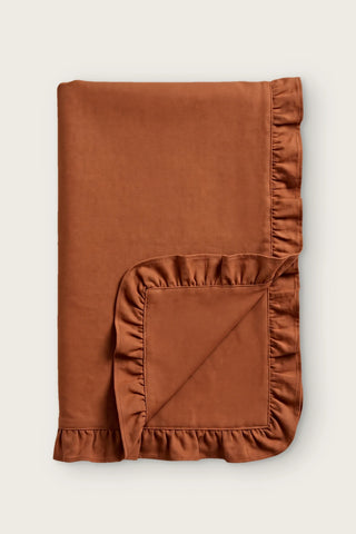 Ruffled linen cotton blend table runner in cinnamon, folded in half with corner turned back