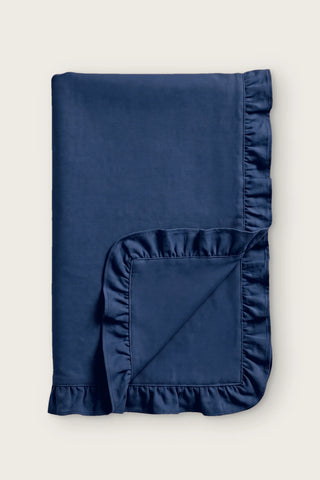 Ruffled linen cotton blend table runner in navy, folded in half with corner turned back