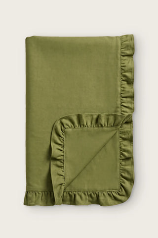 Ruffled linen cotton blend table runner in olive green, folded in half with corner turned back