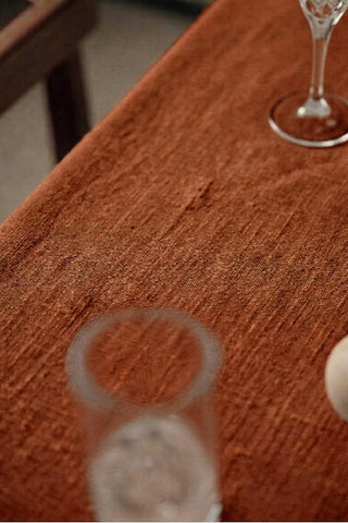 Cinnamon plain linen cotton blend tablecloth fabric texture close-up with a wine glass. 9 sizes, handmade in Denizli, OEKO-TEX. VivaMaison.