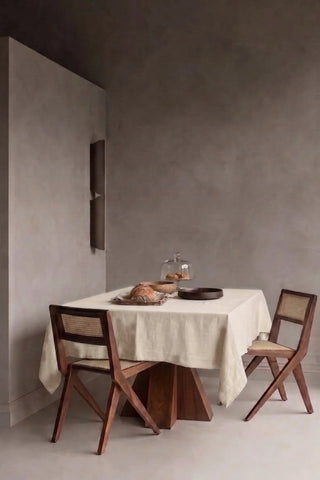 Natural plain linen cotton blend tablecloth on a dining table in a modern dining room with cane chairs. 9 sizes, handmade in Denizli, OEKO-TEX. VivaMaison.