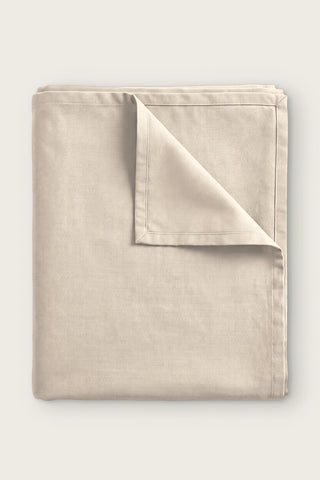 Plain linen cotton blend tablecloth in natural, folded with corner turned back