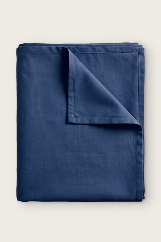 Plain linen cotton blend tablecloth in navy, folded with corner turned back