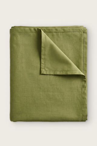 Plain linen cotton blend tablecloth in olive green, folded with corner turned back