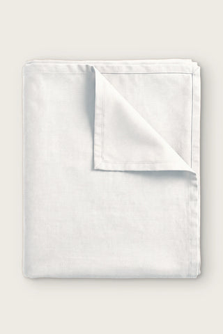 Plain linen cotton blend tablecloth in white, folded with corner turned back