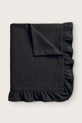 Ruffled linen cotton blend tablecloth in black, folded with corner turned back