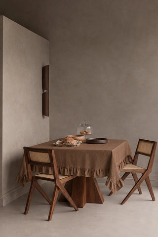 Brown ruffled linen cotton blend tablecloth on a dining table in a modern dining room with cane chairs. 9 sizes, handmade in Denizli, OEKO-TEX. VivaMaison.
