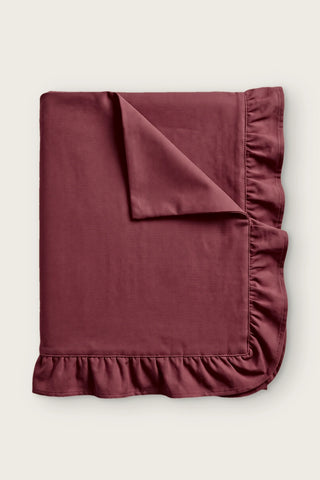Ruffled linen cotton blend tablecloth in burgundy, folded with corner turned back