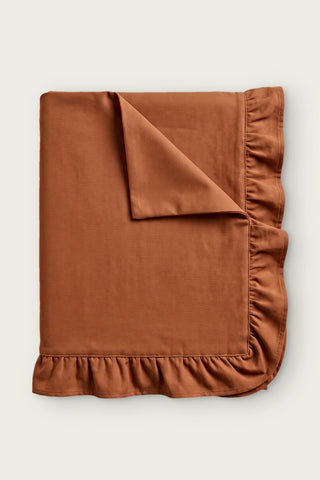 Ruffled linen cotton blend tablecloth in cinnamon, folded with corner turned back