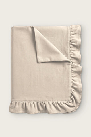 Ruffled linen cotton blend tablecloth in natural, folded with corner turned back