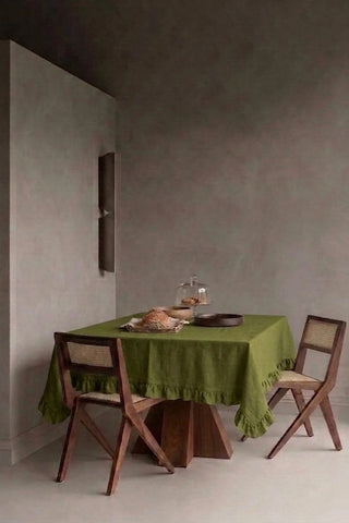 Olive Green ruffled linen cotton blend tablecloth on a dining table in a modern dining room with cane chairs. 9 sizes, handmade in Denizli, OEKO-TEX. VivaMaison.