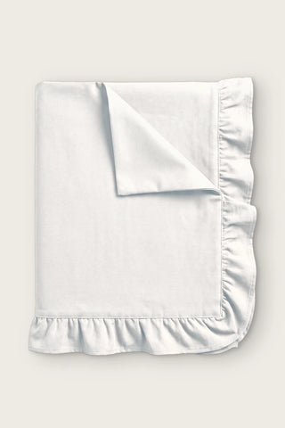 Ruffled linen cotton blend tablecloth in white, folded with corner turned back