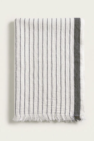 Muslin striped Turkish cotton beach towel peshtemal in black, folded front view with side band and short fringe
