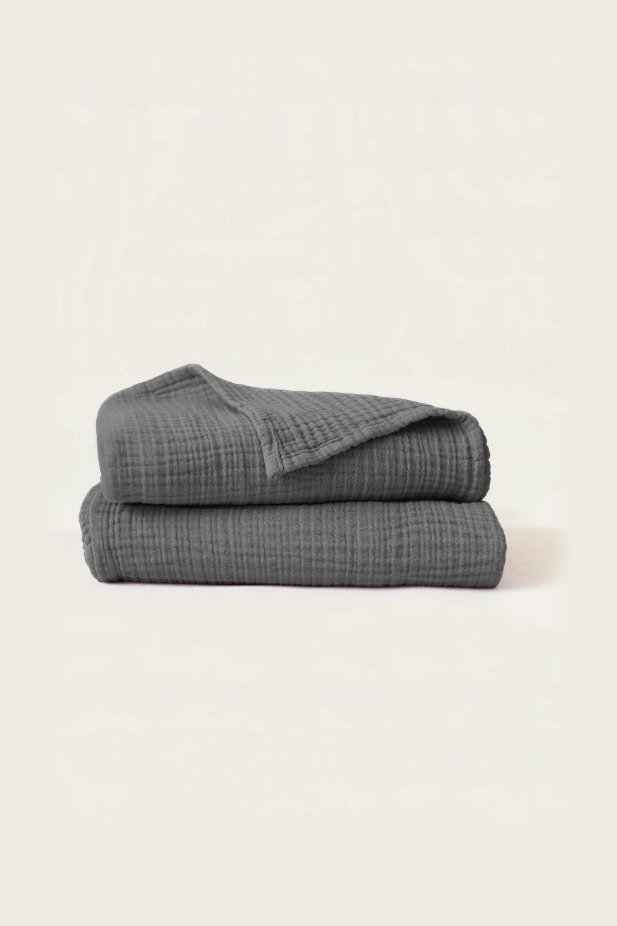 Folded anthracite handwoven muslin towels showing the breathable 4-layer cotton texture by VivaMaison