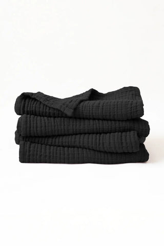Stacked black muslin Turkish cotton towels with soft 4-layer gauze weave, handwoven in Denizli