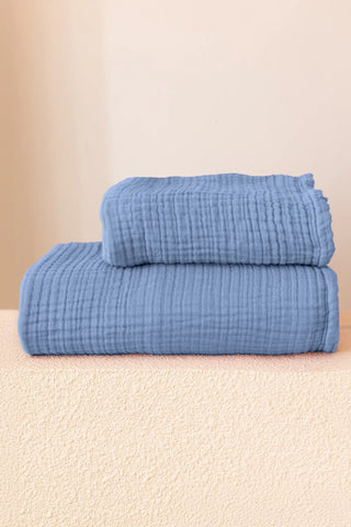 Indigo blue handwoven muslin towel in a styled bathroom setting, OEKO-TEX certified VivaMaison Turkish cotton