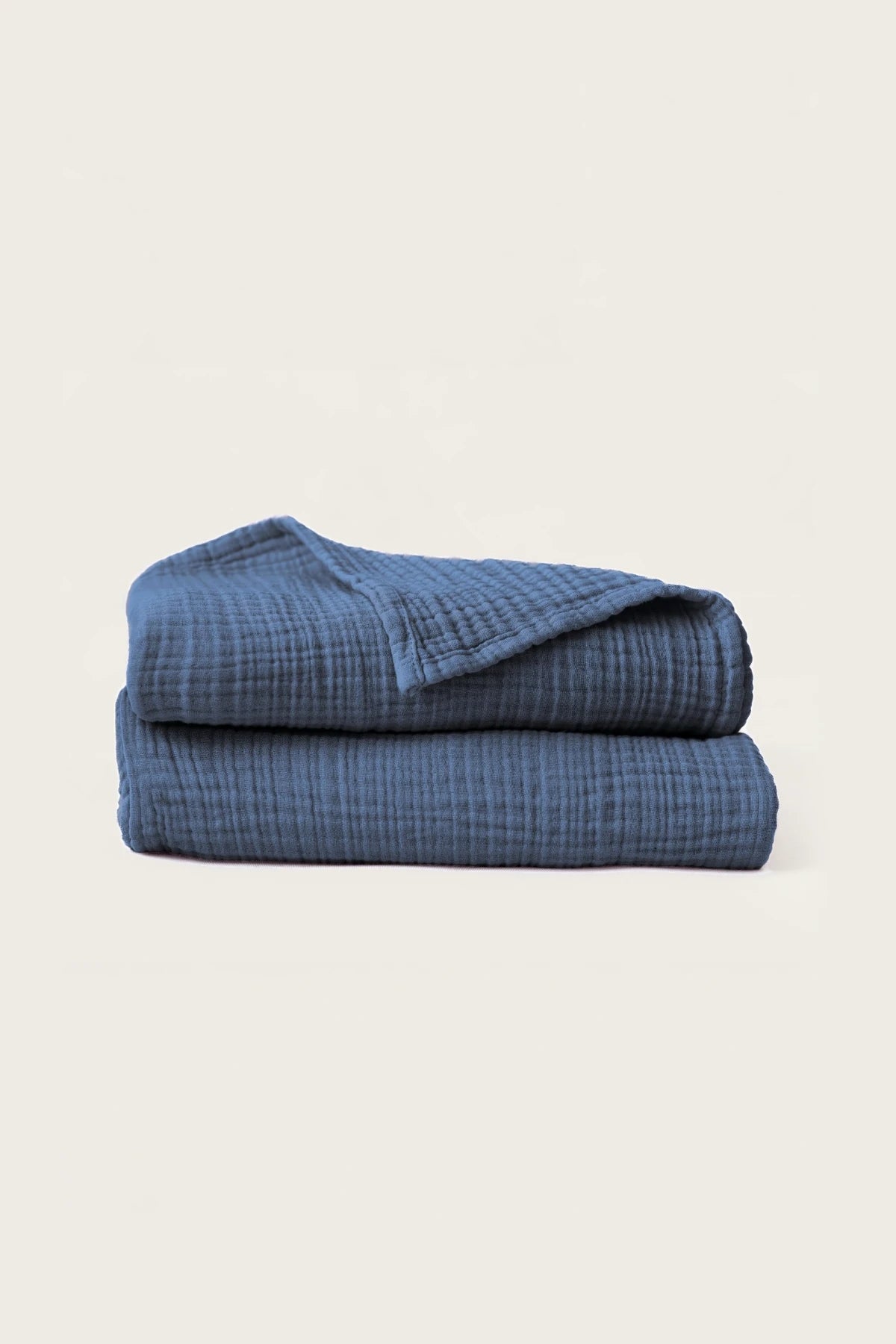 Folded indigo blue handwoven muslin towels showing the breathable 4-layer cotton texture by VivaMaison