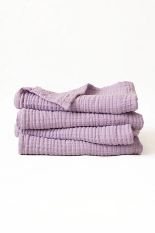 Neatly stacked lilac muslin Turkish towels highlighting the soft gauze layers, OEKO-TEX certified Denizli