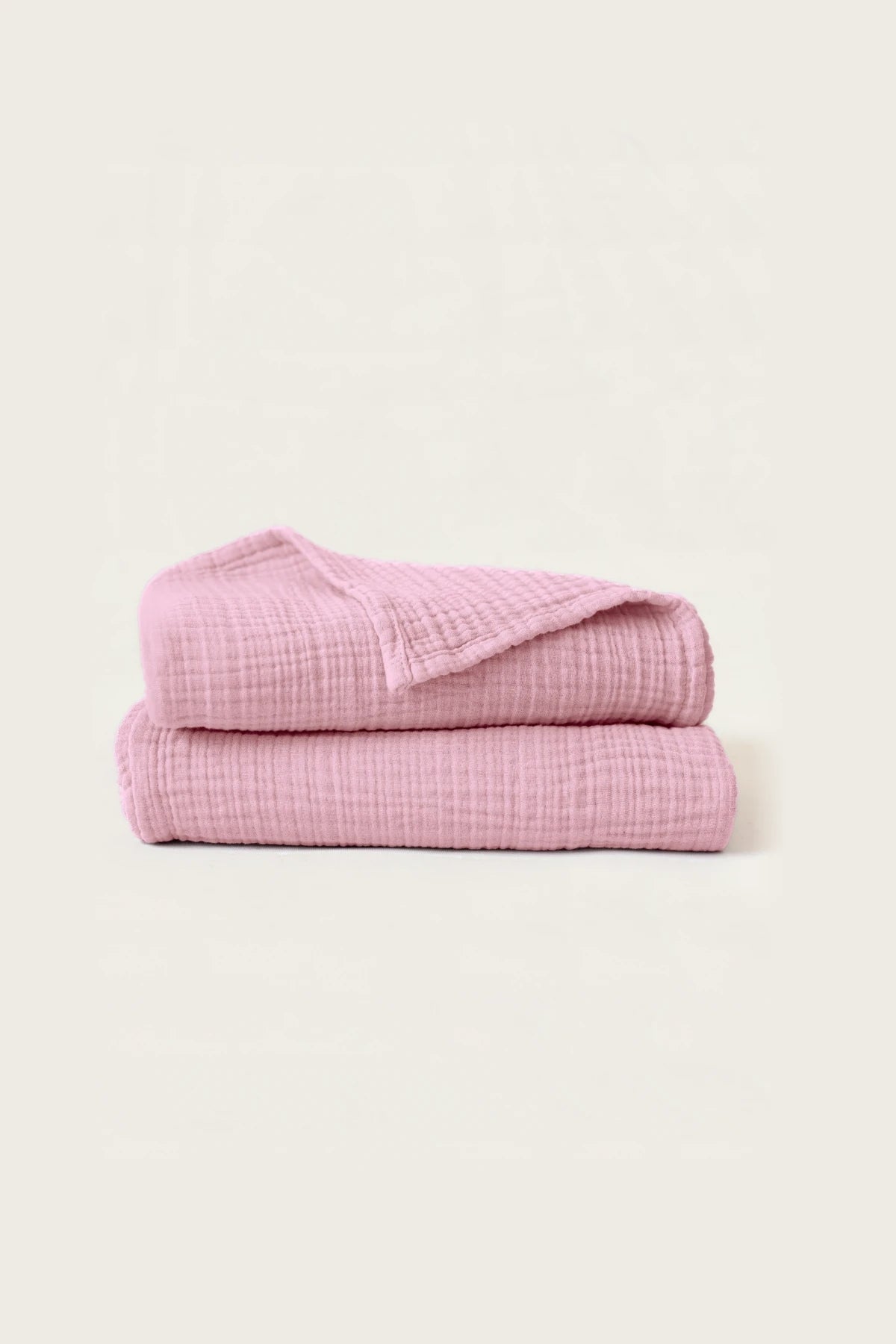 Folded pink handwoven muslin towels showing the breathable 4-layer cotton texture by VivaMaison