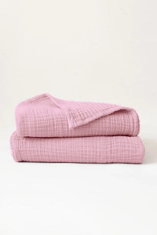 Folded pink handwoven muslin towels showing the breathable 4-layer cotton texture by VivaMaison