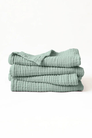 Sage green handwoven muslin towel in a styled bathroom corner, OEKO-TEX certified VivaMaison Turkish cotton